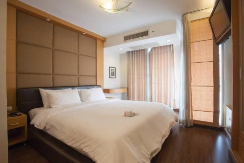 a bedroom with a large bed with a large headboard at Lovely Two Bedroom In Bangkok Downtown Mrtbts in Makkasan