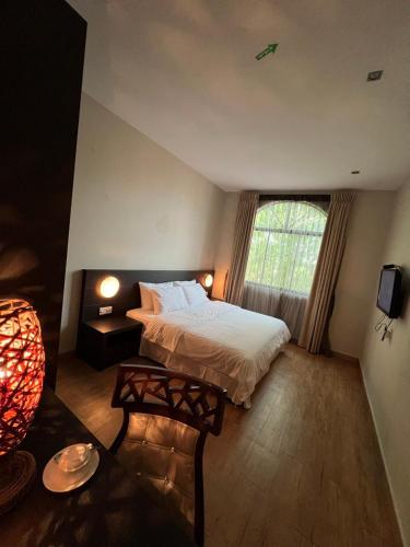 Un dormitorio con una cama grande y una ventana. en Tanjung Villa, en Muar