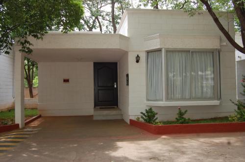 a white house with a black door at SRM Hotel Trichy in Tiruchchirāppalli