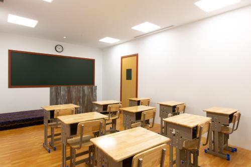an empty classroom with desks and a chalkboard at You Want Motel in Xizhi