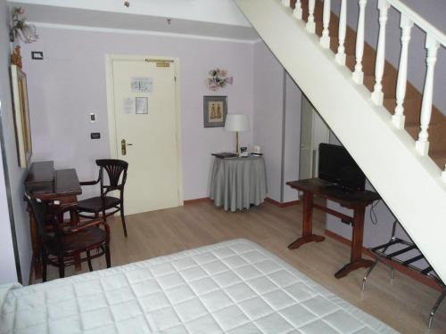 a living room with a staircase and a table and a television at Hotel Continental in Turin