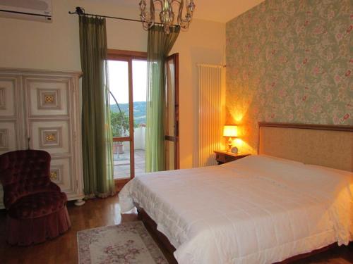 um quarto com uma cama, uma cadeira e uma janela em B&B Il Suono del Bosco em Arcugnano