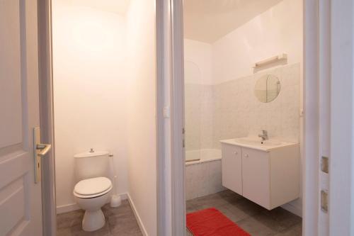 La salle de bains blanche est pourvue de toilettes et d'un lavabo. dans l'établissement Gîte Terracotta de Segré ✰ cuisine ✰ chambre (lit queen size) ✰ salon, à Segré