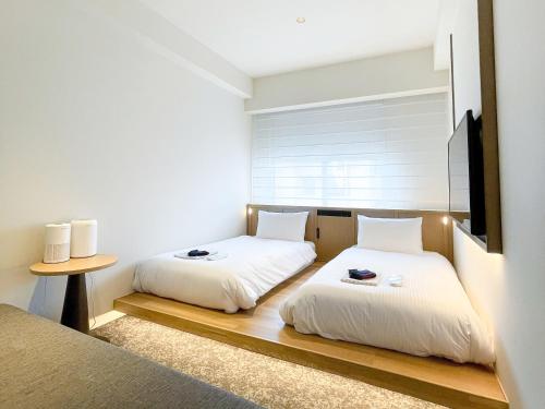 a bedroom with two beds and a tv at Park Hotel Kyoto in Kyoto