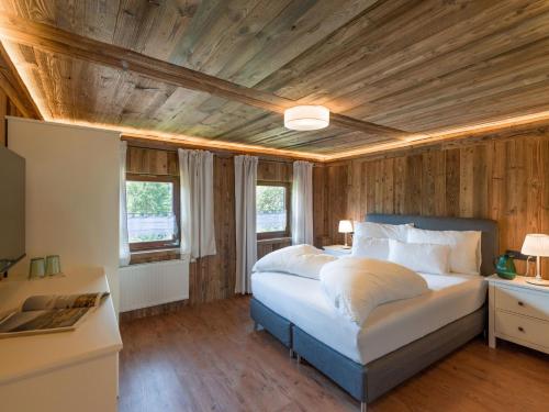 a bedroom with a bed and a wooden ceiling at Oberholzer Landhaus & Appartement in Ellmau
