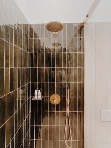 a bathroom with a shower with black and white tiles at Kale Kapi City Living in Chania