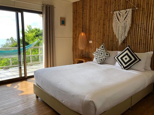 a bedroom with a large bed and a balcony at Bluerama - Adults Only in Haad Pleayleam