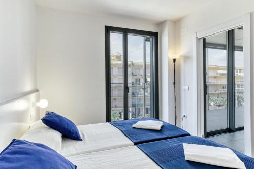 a bedroom with a large bed with blue pillows at Murtra Apartment in Roses
