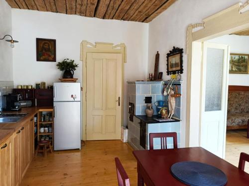 a kitchen with a white refrigerator and a table at Domek Dírná in Dírná
