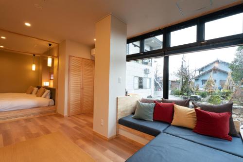 a living room with a blue couch and a large window at Maruyama Onsen Kojyokan in Minami Uonuma