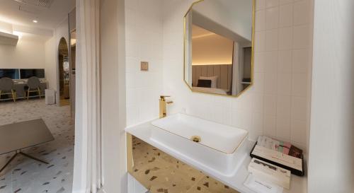 a bathroom with a white sink and a mirror at Denbasta forest Hotel in Busan