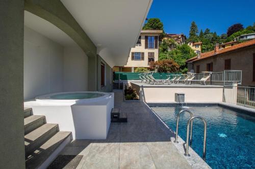 einen Pool mit Badewanne neben einem Gebäude in der Unterkunft Villa Senagra Holidays Lake Como in Menaggio