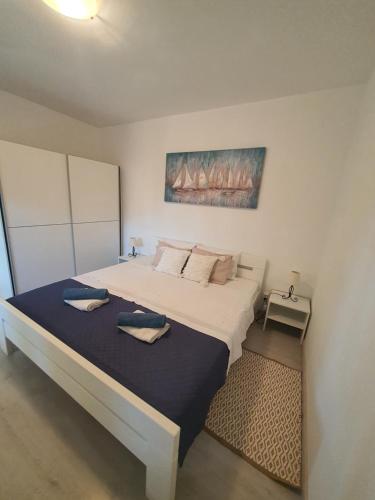 um quarto com uma grande cama branca e 2 almofadas em Vitoria Apartment 1 em Mali Lošinj