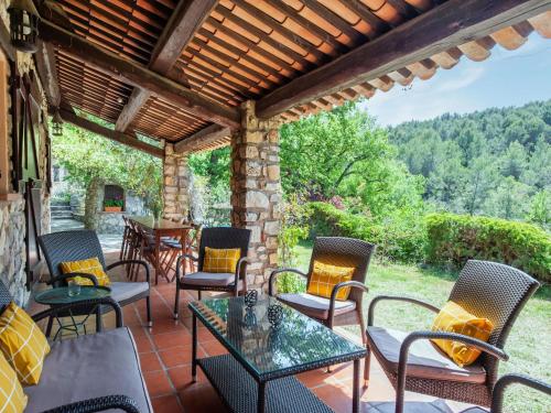 un patio con sedie, tavoli e un muro in pietra di Majestic Villa in Callas France with Private Pool a Callas
