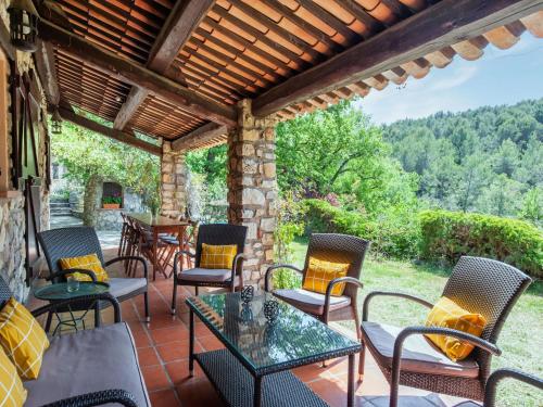 a patio with chairs and tables and a stone wall at Majestic Villa in Callas France with Private Pool in Callas