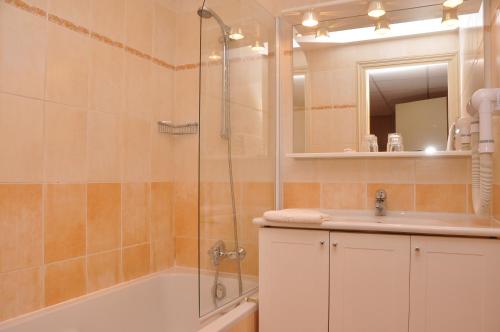 a bathroom with a shower and a tub and a sink at Appart Hotel Lou Castelet in Carros