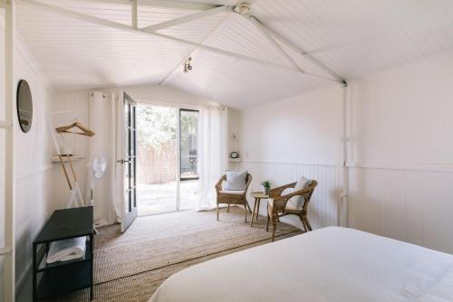 a bedroom with a bed and a table and chairs at Dovestones by the Sea Inverloch in Inverloch