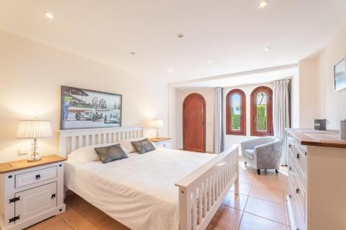 a white bedroom with a white bed and a desk at Villa Riviera in Costa d'en Blanes