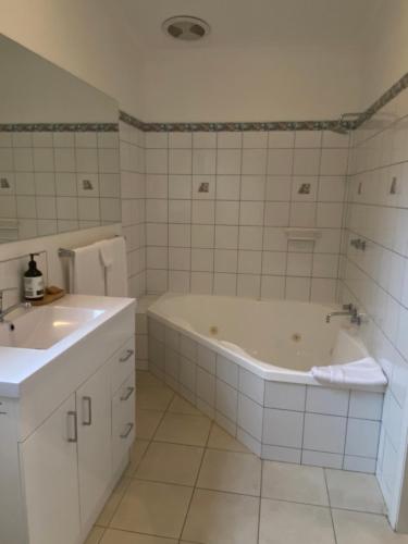 biała łazienka z wanną i umywalką w obiekcie Island Break Cottages w mieście Cowes