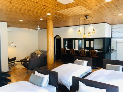 富士河口湖町にあるSAMURISE No.4のベッド2台とソファが備わるホテルルームです。