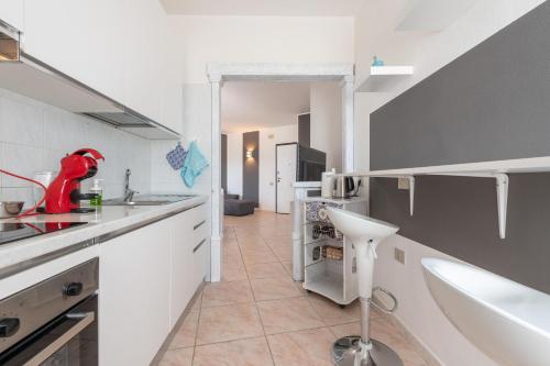 a white kitchen with a sink and a counter at Casa Vacanza Casi in Villasimius