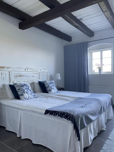 a bedroom with a large white bed with pillows at Glivarpagården in Hammenhög