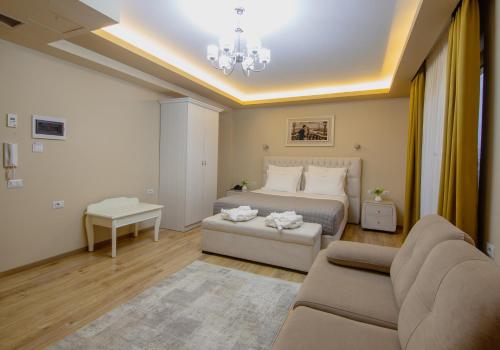 a bedroom with a bed and a couch and a table at Christi's Hotel Borova in Korçë