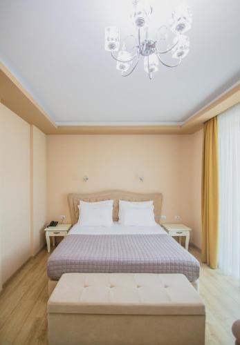 a bedroom with a bed and a chandelier at Christi's Hotel Borova in Korçë