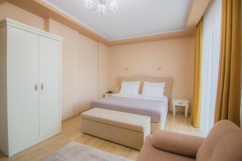 a bedroom with a bed and a couch at Christi's Hotel Borova in Korçë