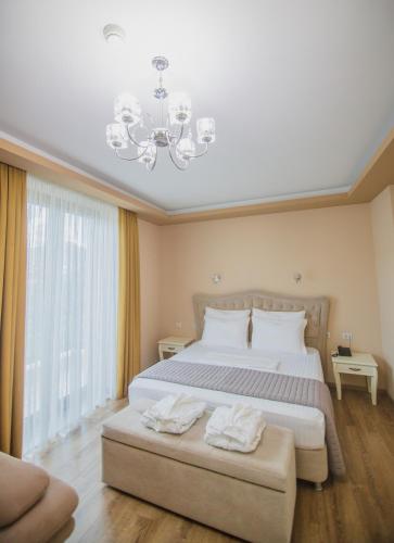 a bedroom with a large bed and a chandelier at Christi's Hotel Borova in Korçë
