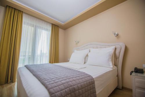 a bedroom with a bed and a large window at Christi's Hotel Borova in Korçë