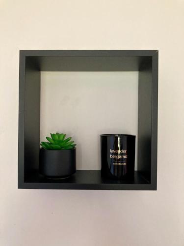 a shelf with a candle and a plant on it at Villa Câline chambres d'hôtes in Vesseaux