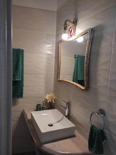 Un baño con un lavabo blanco y un espejo. en Peace & View, en Archangelos