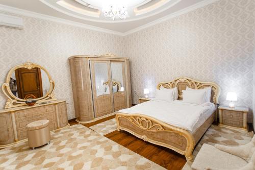- une chambre avec un grand lit et un miroir dans l'établissement Diyor Gold Hotel, à Samarcande