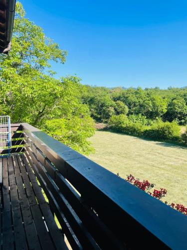 a bench on a deck with a view of a field at Maso Mandrea in Arco