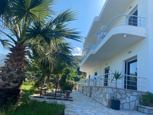 希馬拉的住宿－Hotel Mesun Himare，一座房子,旁边是棕榈树