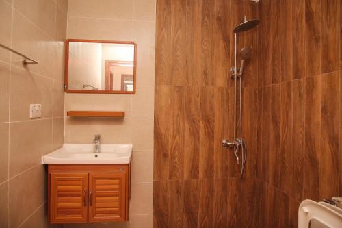a bathroom with a sink and a shower at PALMVILLAGE MIKOCHENI in Dar es Salaam