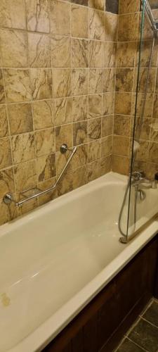 une salle de bain avec une baignoire avec une porte vitrée dans l'établissement Arc 1950 aux pieds des pistes, à Arc 1950