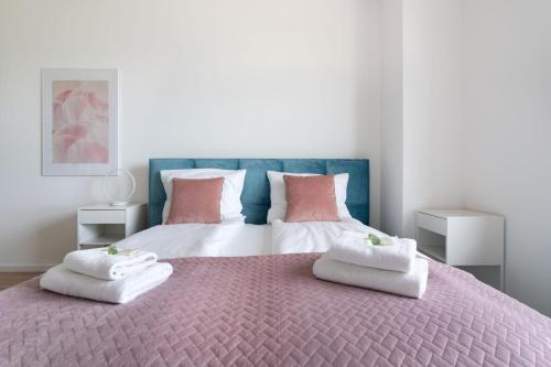 a bedroom with a large bed with two pillows on it at Symphony Baltica Towers Apartamenty in Gdańsk