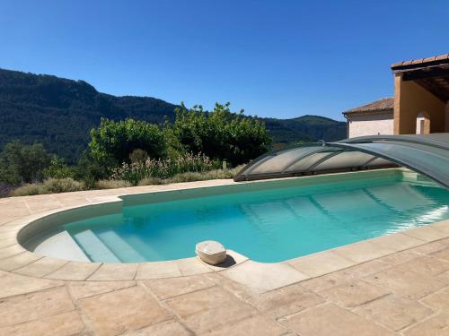 a swimming pool with a dome in a backyard at Villa Câline chambres d'hôtes in Vesseaux