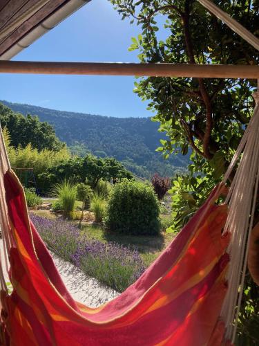 a hammock with a view of a garden at Villa Câline chambres d'hôtes in Vesseaux