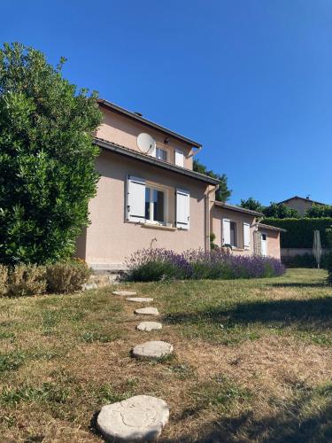 a house with rocks in the grass in front of it at Villa Câline chambres d'hôtes in Vesseaux