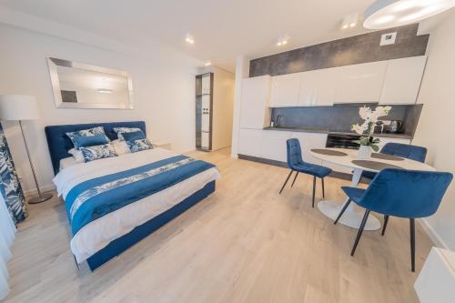 a bedroom with a bed and a table and chairs at Apartament Sapphire Rogowo Pearl in Mrzeżyno