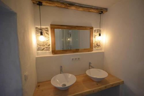 een badkamer met 2 wastafels en een spiegel aan de muur bij Sommerfrische Tschengls in Lasa