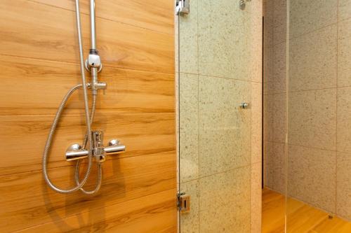 La salle de bains est pourvue d'une douche et d'un mur en bois. dans l'établissement Olumpoy Residences, à Thessalonique
