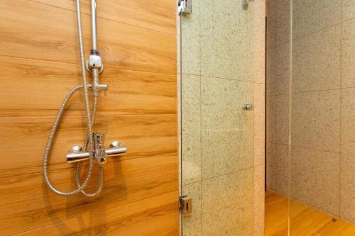 une douche dans une salle de bain avec un mur en bois dans l'établissement Olumpoy Residences, à Thessalonique
