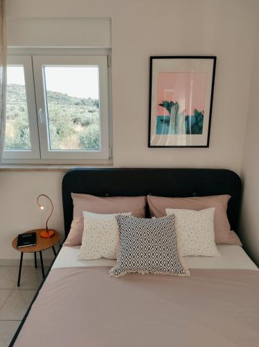 a bedroom with a large bed with two windows at Dream Apartment Milna in Milna