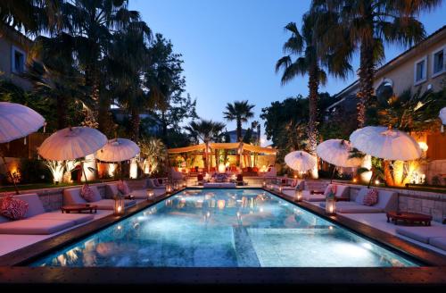 a swimming pool with chairs and umbrellas next to a building at La Capria Suite Hotel Alacati in Alacati