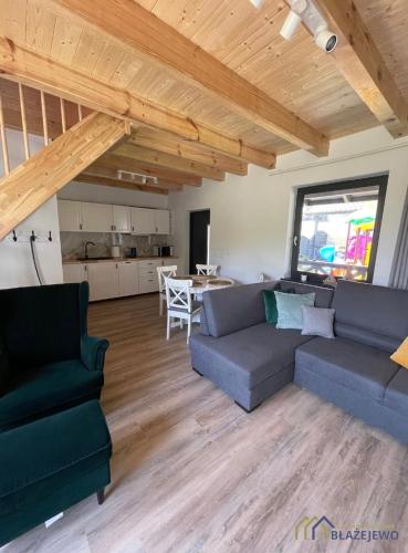 a living room with a couch and a dining room at Domki Błażejewo in Łukęcin