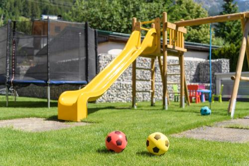 a playground with two soccer balls on the grass at Anthony's Peaks & Pillows in Sankt Anton am Arlberg